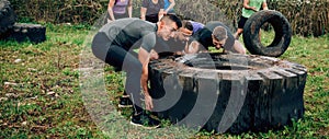 Participants in an obstacle course turning a wheel