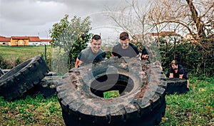 Participants in an obstacle course turning a wheel