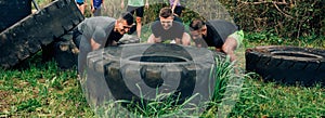 Participants in an obstacle course turning a wheel