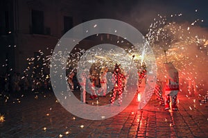 Participants of spectacle Correfocs (fire runs) dancing with fir photo
