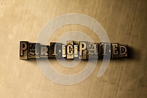 PARTICIPATED - close-up of grungy vintage typeset word on metal backdrop photo