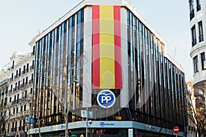 Partido popular building at GÃÂ©nova 13 and big Spanish flag on the facade. PP logo
