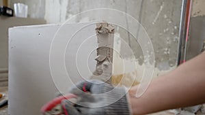 Partition made of tongue-and-groove slabs. A mason applies cement adhesive to a brick when constructing an interior wall