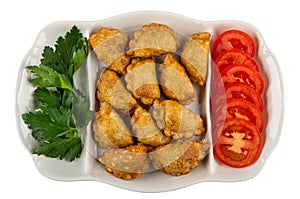 Partitioned dish with patties, parsley, tomato isolated on white. Top view