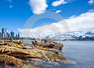 Sydney Harbour with nice rocks in the foreground the soft waves crashing on the shore NSW Australia