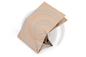 Partly folded light brown paper packing bag with flat bottom