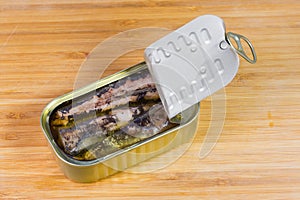 Partly open tin can of canned fish in cooking oil