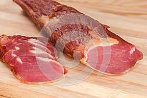 Partly sliced dry-cured pork tenderloin, fragment close-up