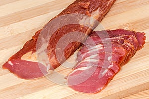 Partly sliced dry-cured pork tenderloin, fragment close-up