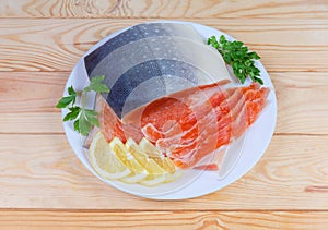 Partly sliced salted arctic char on dish on rustic table