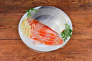 Partly sliced salted arctic char on dish on rustic table