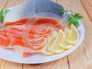 Partly sliced salted arctic char on dish on rustic table