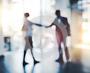 Partnering up to get ahead. Defocused shot of two businesspeople shaking hands in an office.