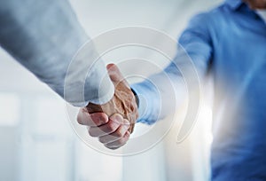 Partnering up to improve their business performance. Closeup shot of a two unrecognizable businessmen shaking hands in