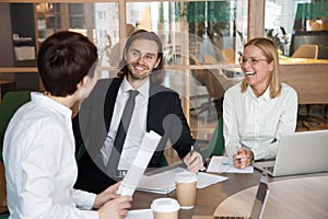 Partners having friendly conversation laughing during business m