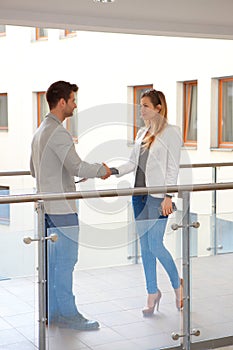 Partners shaking hands in corridor