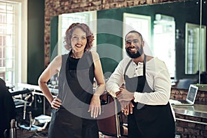 Partners in style. two young hairstylists standing together in their salon.