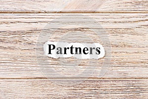 Partners of the word on paper. concept. Words of Partner on a wooden background