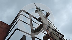 Parts of abandoned fishing boat. Clip. Abandoned boat with rusty parts on cloudy day. Abandoned fishing boat on seashore