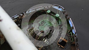 Parts of abandoned fishing boat. Clip. Abandoned boat with rusty parts on cloudy day. Abandoned fishing boat on seashore