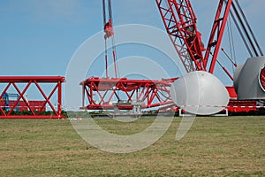 Parts of a gigantic construction crane are assembled here by the crane, for building a wind turbine