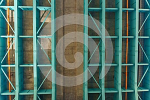 Parts of a modern metal bridge in close-up against a blue sky background. Metal structures connected by large bolts and nuts to a