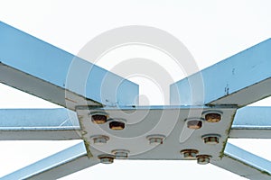 Parts of a modern metal bridge in close-up against a blue sky background. Metal structures connected by large bolts and nuts to a