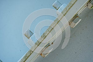 Parts of a modern metal bridge in close-up against a blue sky background. Metal structures connected by large bolts and nuts to a