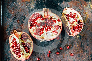 Parts of pomegranate fruit on black rustic sufrace.
