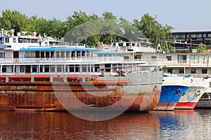 Parts of rusty cargo ships and lowered anchors on river