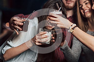 Party with alcohol. Group of young friends smiling and making a toast in the nightclub