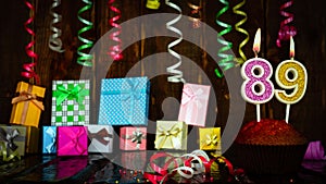 Party birthday background with number 89. Beautiful background anniversary copy space with burning candles. Gift boxes with