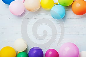 Party or birthday banner with colorful balloons on blue wooden background top view. Flat lay style.