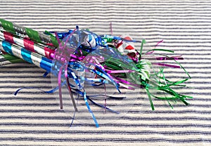 Party blower noisemakers on a striped tablecloth photo