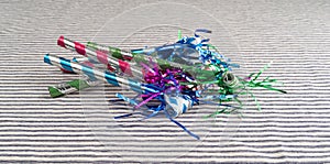 Party blower noisemakers on a striped tablecloth photo