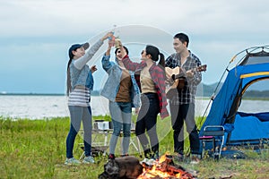 Party Camping.  Group asian family and friends travel enjoy party and roasted sausages relax