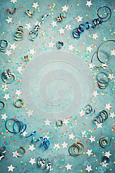 Party, carnival or birthday frame with colorful confetti and streamer on vintage blue table top view. Flat lay style. Holiday.