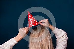 Party and celebration.Woman holding paper red hat with stars on