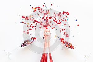 Party with champagne bottle, glasses and colorful party streamers on white background top view