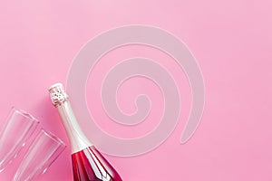 Party with champagne bottle and glasses on pink background top view space for text