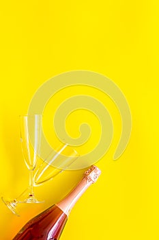 Party with champagne bottle and glasses on yellow background top view space for text
