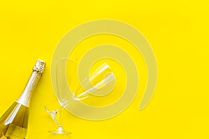 Party with champagne bottle and glasses on yellow background top view space for text