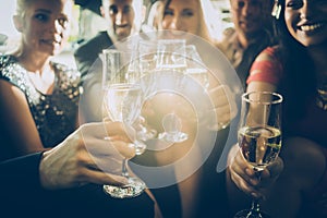Party crowd clinking glasses with champagne photo
