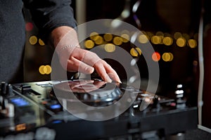 Party dj mix music tracks on edm festival in night club.Hands of disc jockey mixing musical set on sound mixer controller in