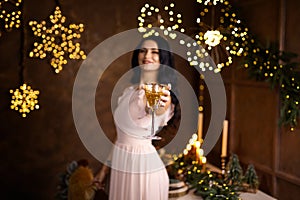 woman in beautiful dress with glass of sparkling wine over Christmas lights