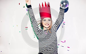 Party girl in colorful spotlights and confetti smiling on white background celebrating brightful event, wears stripped