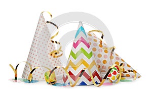 Party hats, blowers and confetti streamers on white background