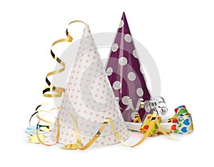 Party hats, blowers and confetti streamers on white background