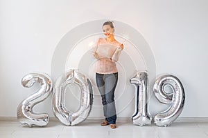 Party, holidays and people concept - Happy young woman celebrating New Year with big 2019 symbol and sparklers