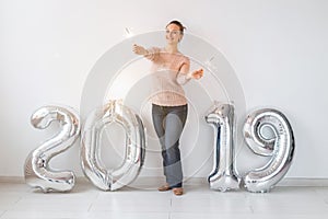 Party, holidays and people concept - Happy young woman celebrating New Year with big 2019 symbol and sparklers